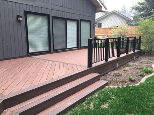 Composite deck installation in Calgary backyard with steps and railing