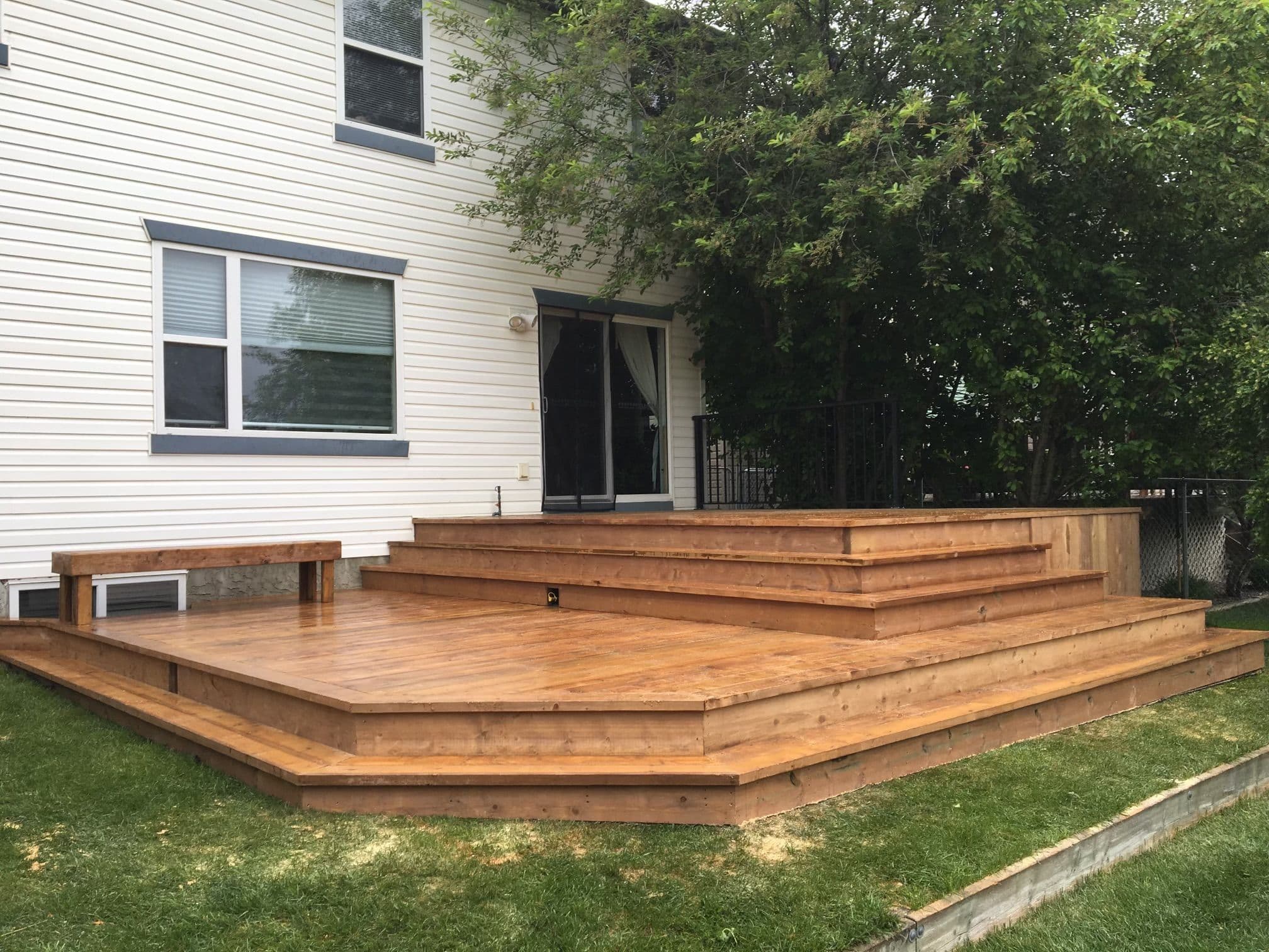 Wood deck installation in Calgary backyard with multi-level design and natural finish