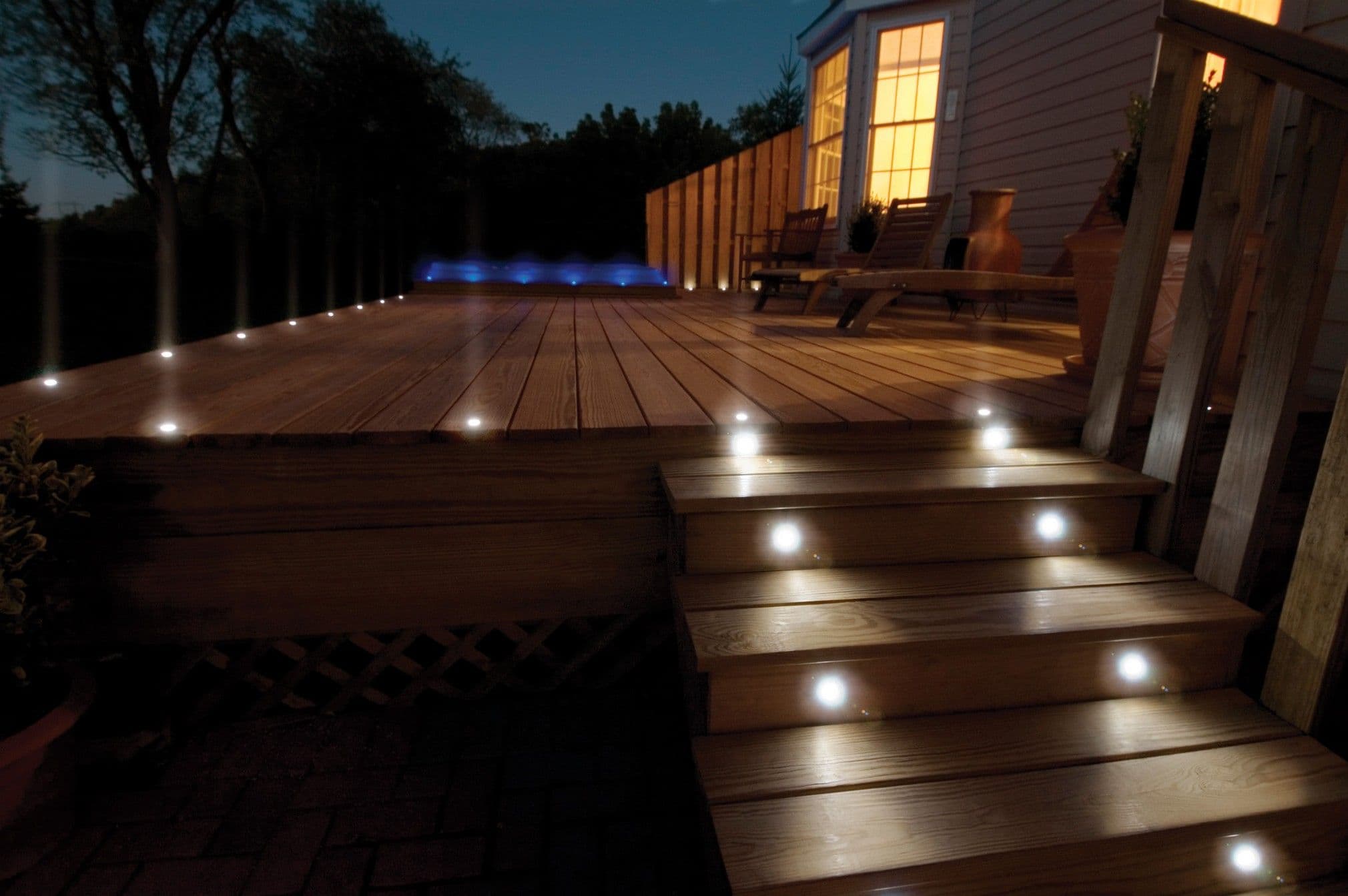 Backyard deck in Calgary with built-in stair lighting and evening outdoor lighting features